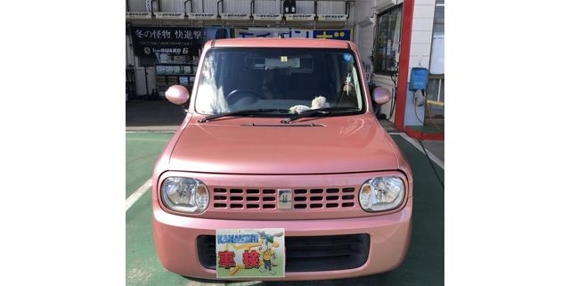 愛知県江南市の整備工場前にて撮影されたスズキ アルト ラパンのピンク色車両。正面からのアングルで“KANAMORI 車検”プレート付き。