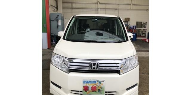 正面から撮影したホンダ ステップワゴンの白いミニバン。力強いフロントマスクとシンプルで実用性の高いデザインが際立つ。