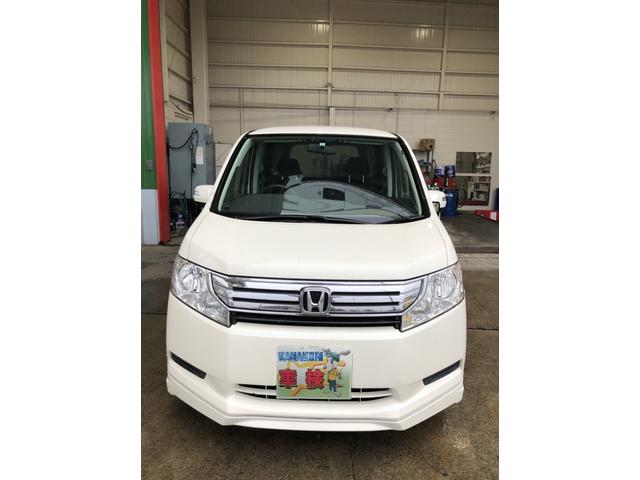 正面から撮影したホンダ ステップワゴンの白いミニバン。力強いフロントマスクとシンプルで実用性の高いデザインが際立つ。