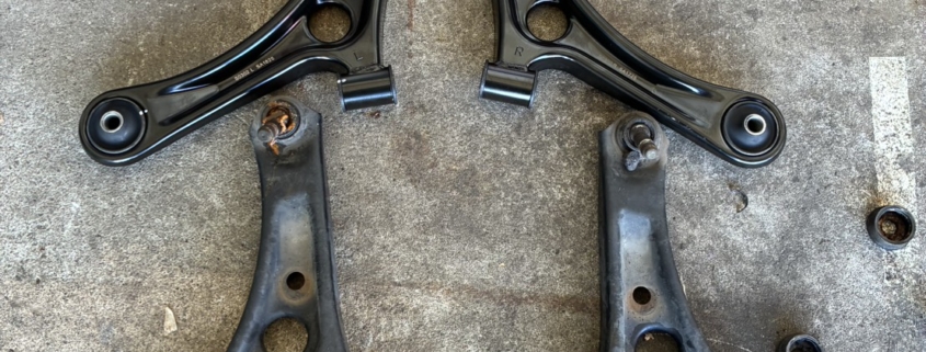 新品ロアアーム(左右)と取り外した旧ロアアームの比較。新旧で金属の艶やジョイント部の劣化具合が明確にわかる。