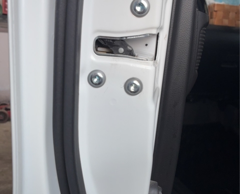 ダイハツ タント 助手席ドア内部 ドアロック固定部の状態を点検している様子